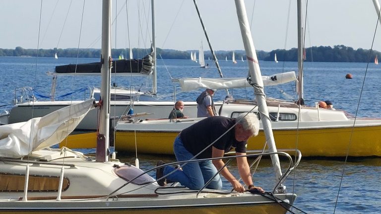 Absegeln 2025 am 20. September 2025. Die Segler legen in Ascheberg an den Stegen und den Takeltonnen vor dem Hafen der Ascheberger Seglergemeinschaft an. Im Hintergrund sind weitere Segelboote auf dem Weg nach Ascheberg zu sehen.