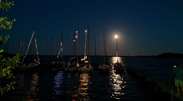 Mond über dem Plötner See - mit Lampions geschmückte Boote.