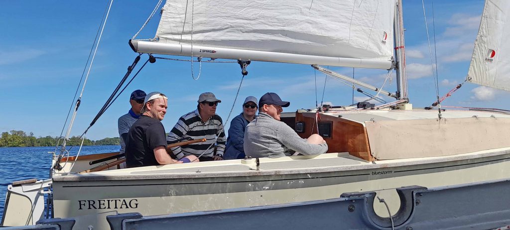Eltern beobachten ihre Kinder vom Segelboot aus.